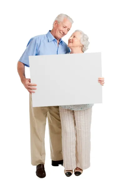 Удовлетворенная пожилая пара со знаком — стоковое фото