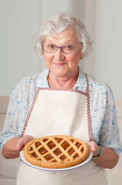 Senior lady with homemade cake — Stock Photo, Image