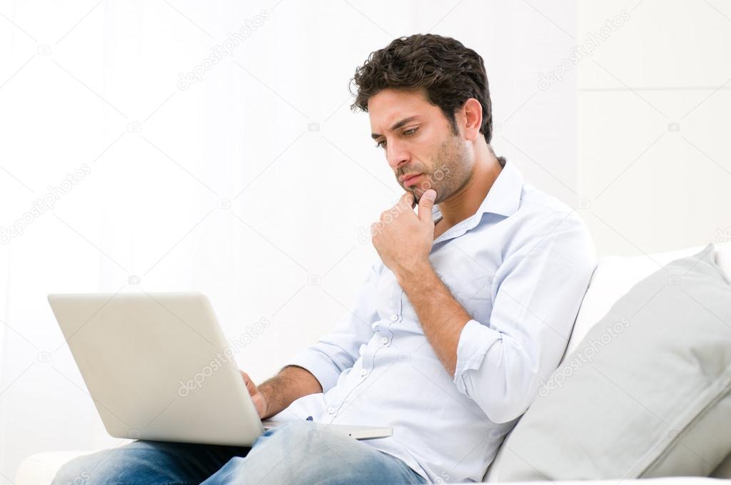 Pensive worried guy at laptop