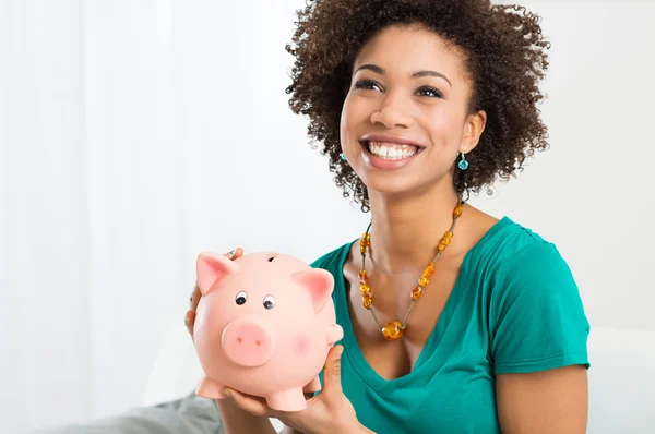 Glückliche Frau hält Sparschwein — Stockfoto