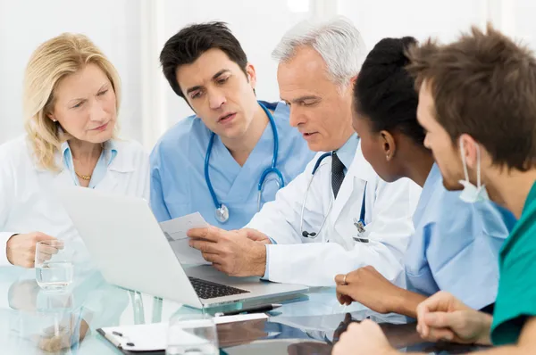 Equipo de médicos examinando informes — Foto de Stock