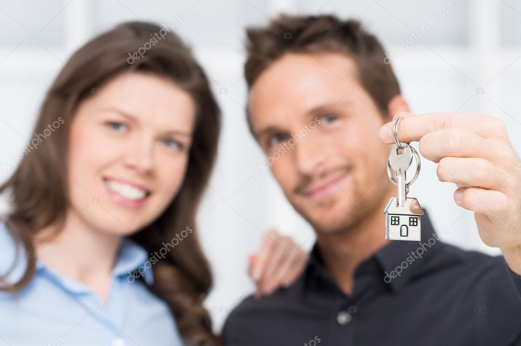 Young Couple Showing Keys Of New House