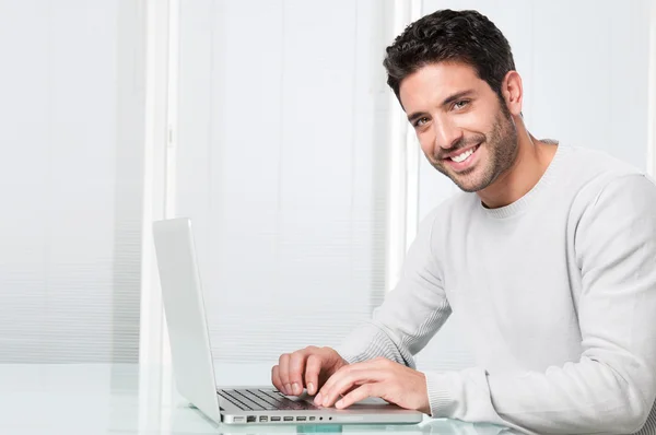 Усміхнений чоловік працює на ноутбуці — стокове фото