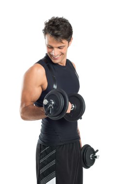 Dambıllarla egzersiz yapan genç adam.