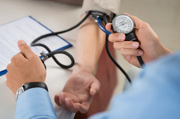 Médico mede a pressão no paciente — Fotografia de Stock