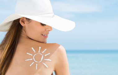 kadının omuz güneş koruma kremi ile çizilen güneş