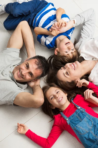 Lächelnde Familie auf dem Boden liegend — Stockfoto