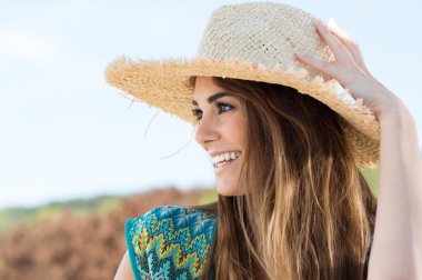 Hasır şapka giyen genç bir kadın.