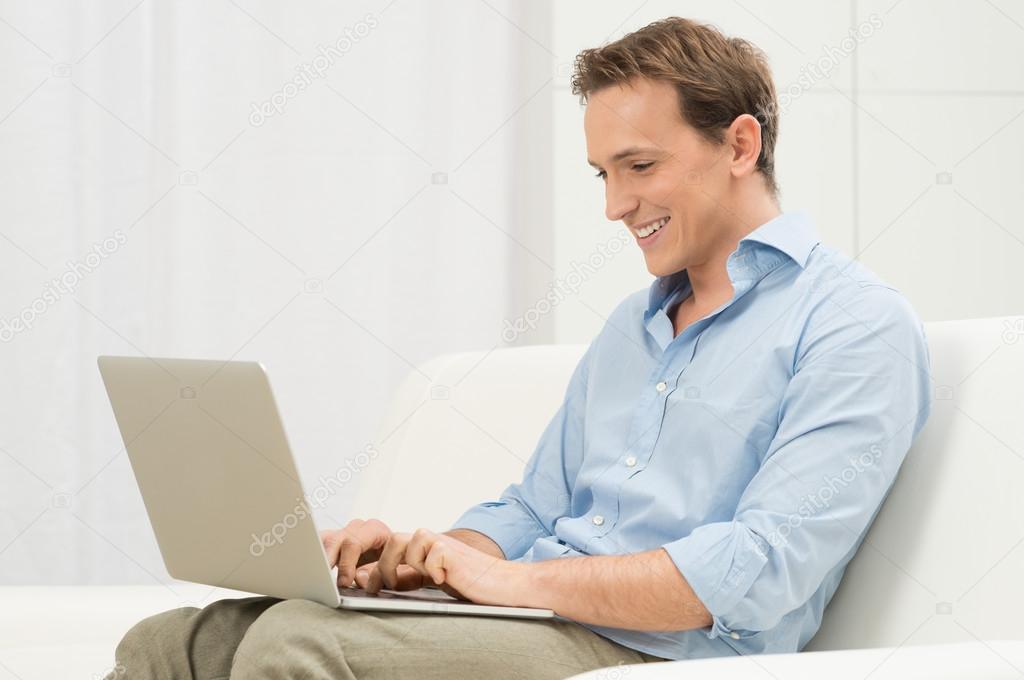 Man On Sofa With A Laptop