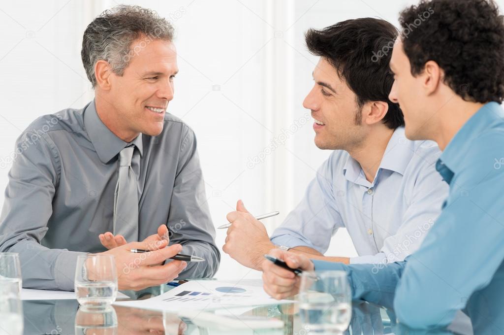 Three Businessmen Discussing In Meeting
