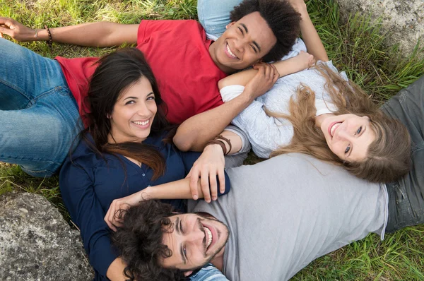 Група друзів, що лежать на траві — стокове фото