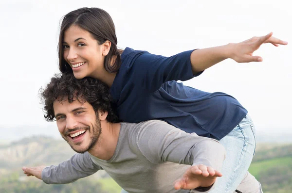 Man Piggybacking Woman Stock Photo