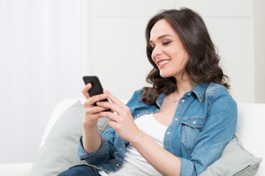 Smiling Young Woman Holding Cellphone clipart