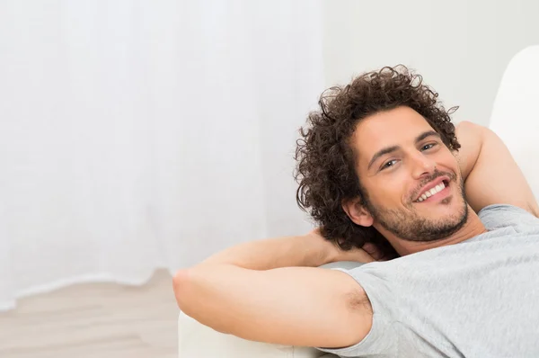 Homem feliz descansando no sofá — Fotografia de Stock