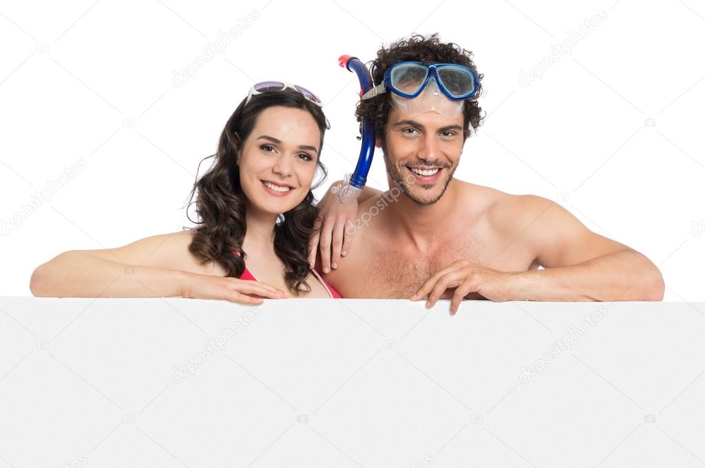 Couple In Swimsuit Holding Sign