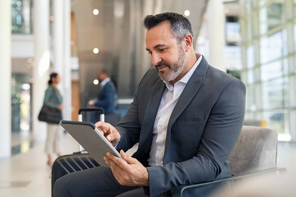 Başarılı Bir Adamı Havaalanı Salonunda Oturup Dijital Tablet Üzerinde Çalışıyor — Stok fotoğraf