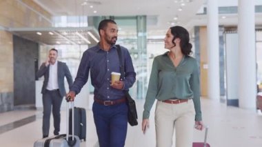 İş arkadaşları modern ofiste yürüyüp konuşuyorlar. Başarılı iş adamı ve iş kadını havaalanında tramvayla yürürken iş tartışıyorlar. İş seyahati ve iş seyahati kavramı.