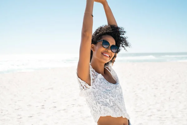 在海滩放松的同时微笑着年轻的非洲裔美国女人 美丽的黑人女人周末在海滨边跳舞边看相机 快乐的无忧无虑的女孩 戴着墨镜 带着复制空间 自由和积极 — 图库照片