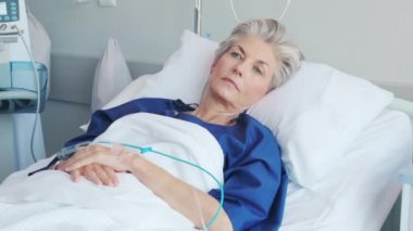 Elinde serum serumuyla hastane yatağında yatarken iyileşen olgun bir kadın. Ameliyattan sonra iyileşmekte olan gri saçlı eski bir hastanın portresi. Hastane koğuşunda yatağında kameraya bakarken mutlu bir son sınıf öğrencisi..