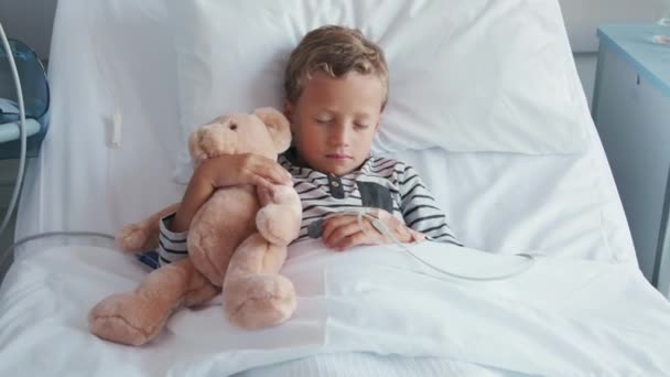 Kleine Schattige Jongen Knuffelende Teddybeer Met Intraveneus Infuus Hand Slapend — Stockvideo