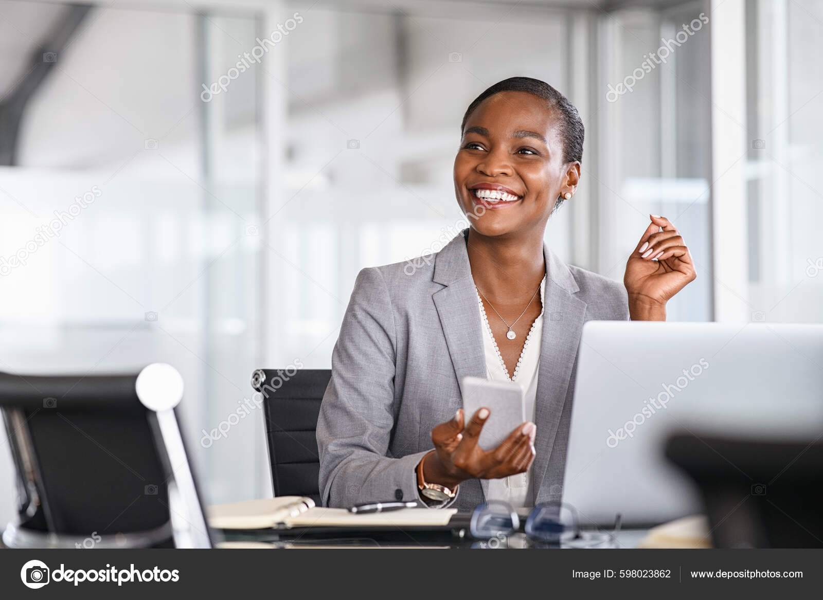 African Black Business Woman Using Smartphone While Working Laptop