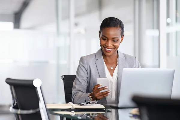 African American Businesswoman Using Smartphone While Working Laptop Office Smiling — Stockfoto