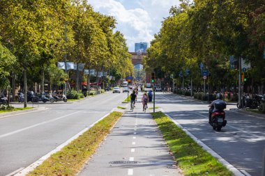 Barcelona, İspanya - 20 Eylül 2021 Sant Joan Bulvarı 'nda bisiklet yolu. Orta şeritte bisikletçilerin olduğu şehir manzarası. Turist ve yöre sakinleri motoru hızlı kullanıyor. Bu da kalabalık şehirden geçmek anlamına geliyor.