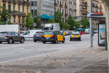 Barselona, İspanya - 21 Eylül 2021: Barcelona yolu üzerindeki Taksi. Taksi şoförü trafik ışıklarında bekliyor. Taksiler toplu taşıma konseptinin bir parçasıdır. Sokaktaki taksi arabaları.