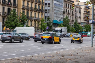 Barselona, İspanya - 21 Eylül 2021: Barcelona yolu üzerindeki Taksi. Taksi şoförü trafik ışıklarında bekliyor. Taksiler toplu taşıma konseptinin bir parçasıdır. Sokaktaki taksi arabaları.