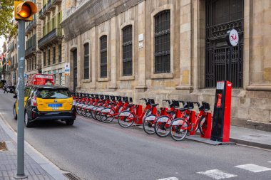 Barselona, İspanya - 21 Eylül 2021: Sokaktaki otoparkta kiralanan bisikletler. Kamu bisiklet sistemi kiralıyorum. Sağlıklı bir yaşam tarzı. Barselona 'da kiralık bisikletler için bisiklet rafı