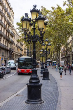 Barselona, İspanya - 21 Eylül 2021: Carrer la rambla Bulvarı, Barselona Şehir Merkezi. Antik geleneksel sokak lambaları. Kamu otobüsü dar yoldan geçiyor..