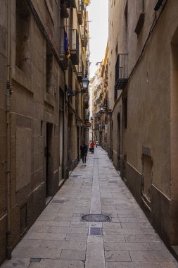 Barselona, İspanya - 23 Eylül 2021: Şehrin dar sokaklarına bakın. Büyük caddeleri birbirine bağlayan dar sokakların yanında. Geçit boyunca küçük dükkanlar ve kafeler var..