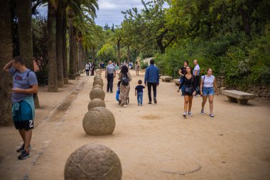 Barcelone, İspanya - 23 Eylül 2021: İnsanlar ve aileleri Park Guell 'de yürüyor ve yaz gününün tadını çıkarıyorlar. Parc Guell, bahçeler ve mimari elementlerden oluşan bir kamu park sistemidir.