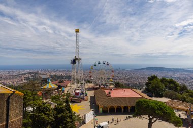 Barselona, İspanya - 22 Eylül 2021: Barcelona ufuk çizgisi üzerinde hava manzarası. Tibidabo Dağı 'nın zirvesinden geniş açılı panoramik görüntü. Ön planda Tibidabo Eğlence Parkı, ufukta deniz.