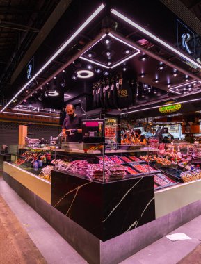 Barcelona, İspanya - 23 Eylül 2021: Mercat de la Boqueria 'nın içinde veya sadece La Boqueria' da, La Rambla, Barcelona 'da büyük bir kamu pazarı. Jambon, salam ve pastırma çeşitleriyle kasap tezgahı.