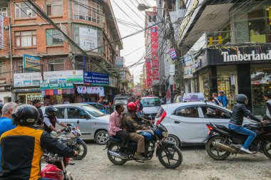 Katmandu, Nepal - 30 Ekim 2021: Başkent Nepal 'de işlek cadde. Motosikletler ve arabalar yoldaki sınırlı alanı paylaşıyorlar. Sokağın üstünden geçen elektrik kablosu. Tozlu sokak