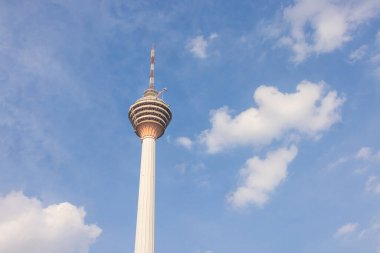 Kuala Lumpur, Malezya - 16 Haziran 2022: Menara KL kulesi veya Kuala Lumpur TV kulesi. Mavi gökyüzünde bulutlar, Malezya başkentinin arkasında beyaz bulutlar. Şehirdeki gözlem kulesi.