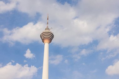 Kuala Lumpur, Malezya - 16 Haziran 2022: Menara KL kulesi veya Kuala Lumpur TV kulesi. Mavi gökyüzünde bulutlar, Malezya başkentinin arkasında beyaz bulutlar. Şehirdeki gözlem kulesi.