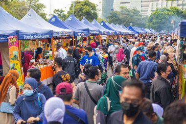 Kuala Lumpur, Malezya - 21 Haziran 2022: Sokaktaki taze pazar. Sebze, meyve ve taze tavuk küçük tezgahlarda satılır. Birçok insan kabinlerin arasındaki sokakları itiyor.