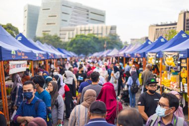 Kuala Lumpur, Malaysia - June 21, 2022: Fresh market on the street. Vegetable, Fruits and fresh chicken are sold on small stands. very many people push their way through the alleys between the stalls
