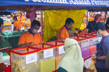 Kuala Lumpur, Malezya - 21 Haziran 2022: İki genç adam buzlu meyve suyunu satmak için hazırlıyor. Malezya 'nın başkentinde geleneksel bir sokak yemeği pazarında. Müşteriler soğuk içecekleri bekliyor.