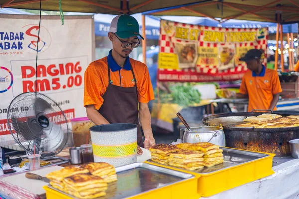 Kuala Lumpur, Malezya - 21 Haziran 2022: KL 'de yeni bir pazarda genç adam, gece pazarında ev yapımı Murtabak pişiriyor. Geleneksel gıda pazarı. Motabbaq doldurulmuş krep ya da tavada kızartılmış ekmek.