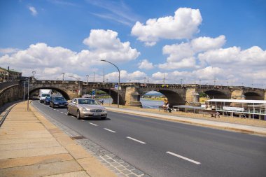 Dresden, Germany - June 28, 2022: At the terrace shore or german Terrassenufer, with view to the Augustus bridge. Pier for the  paddle steamer boats Of the former saxony white fleet. Cars passing