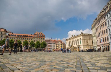Dresden, Almanya - 28 Haziran 2022: Eski Dresden kasabasındaki Neumarkt. Taşımacılık Müzesi 'ne (Verkehrsmuseum) doğru, kaldırım taşlarıyla döşenmiş karenin alçak açılı görüntüsü. Sokaktaki turist