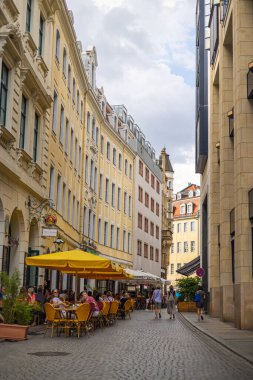 Leipzig, Germany - June 25, 2022: View from Thomaskirchhof onto Klostergasse (Monastery alley) with the Paulaner Restaurant. Parasols and tables invite you to linger outside. Historical old town