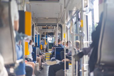 Leipzig, Almanya - 25 Haziran 2022 Leipzig Nakliye Şirketi 'nin tramvay römorkunun içinde. Metropolis 'te toplu taşıma. Mavi sandalyeler boş ve yolcular için hazır. Tramvay ağaçların yanından geçiyor