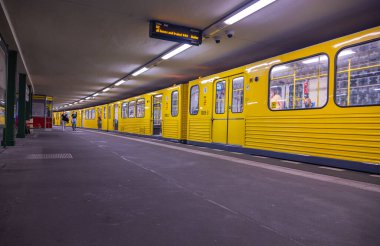 Berlin, Almanya - 29 Haziran 2022: Berlin U-Bahn treni peronda. Metro ve metro trenlerinin sarı vagonları. Berlin 'den geçen turist ve yerel halk için en hızlı yol toplu taşımacılık..