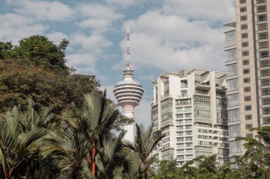 Kuala Lumpur, Malaysia - August 13, 2022: View to the Menara Tower or KL tower through the palm trees of the KLCC park. Long Exposure HDR photo of one of the Kuala Lumpur landmarks. Malaysia icons 