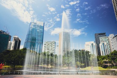 Kuala Lumpur, Malaysia - August 13, 2022: The KLCC Park with the water fountain show in front of the Petronas towers. Long exposure with silky water jet. City oasis around the twin towers Suria KLCC