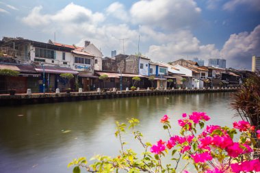 Malacca, Malaysia - August 10, 2022: Along the Melaka river with the old brightly painted houses. Bars and restaurants line the course of the river. Long Exposure capture smooths silky water.
